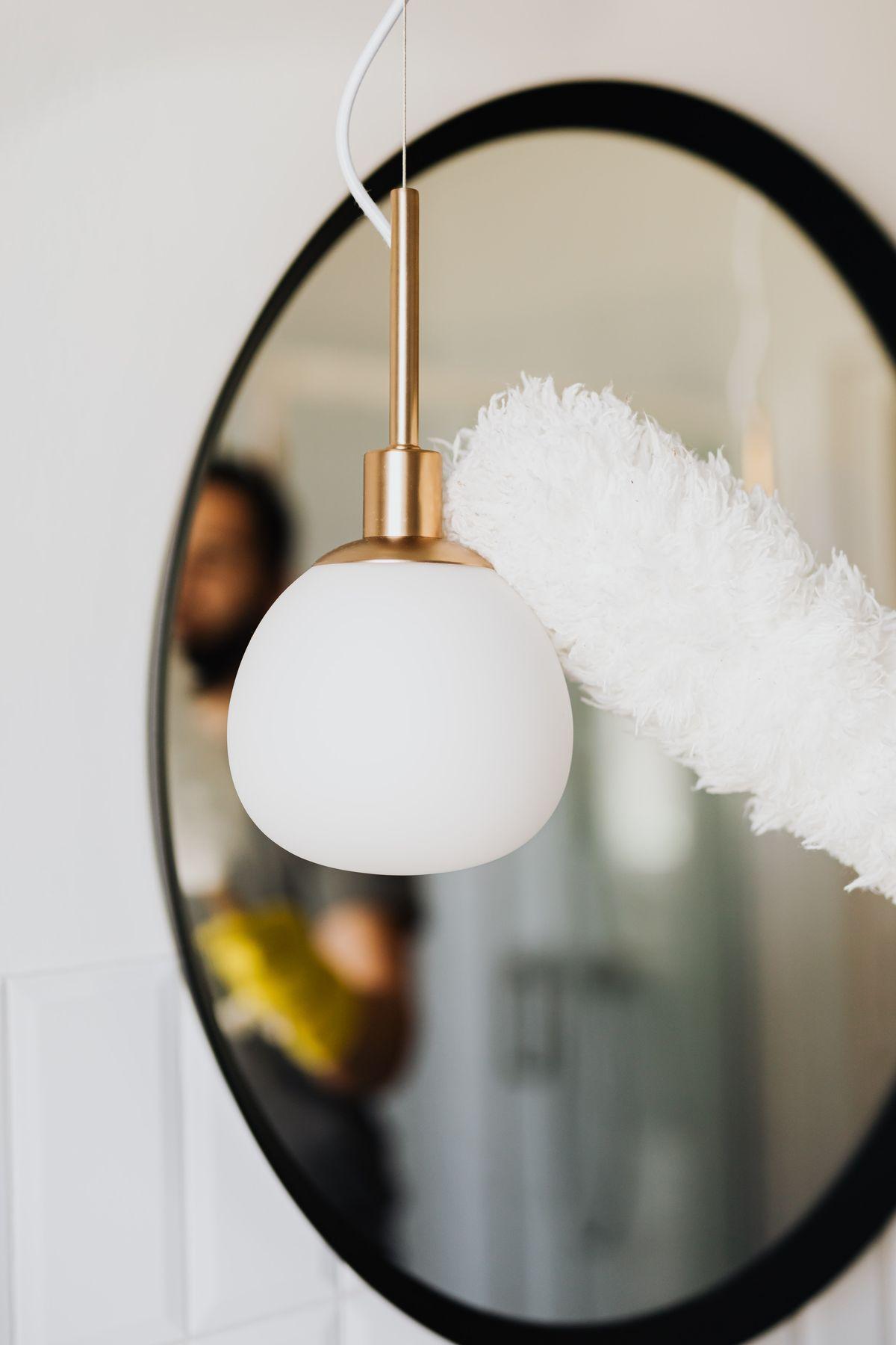 A high-level light fitting being dusted